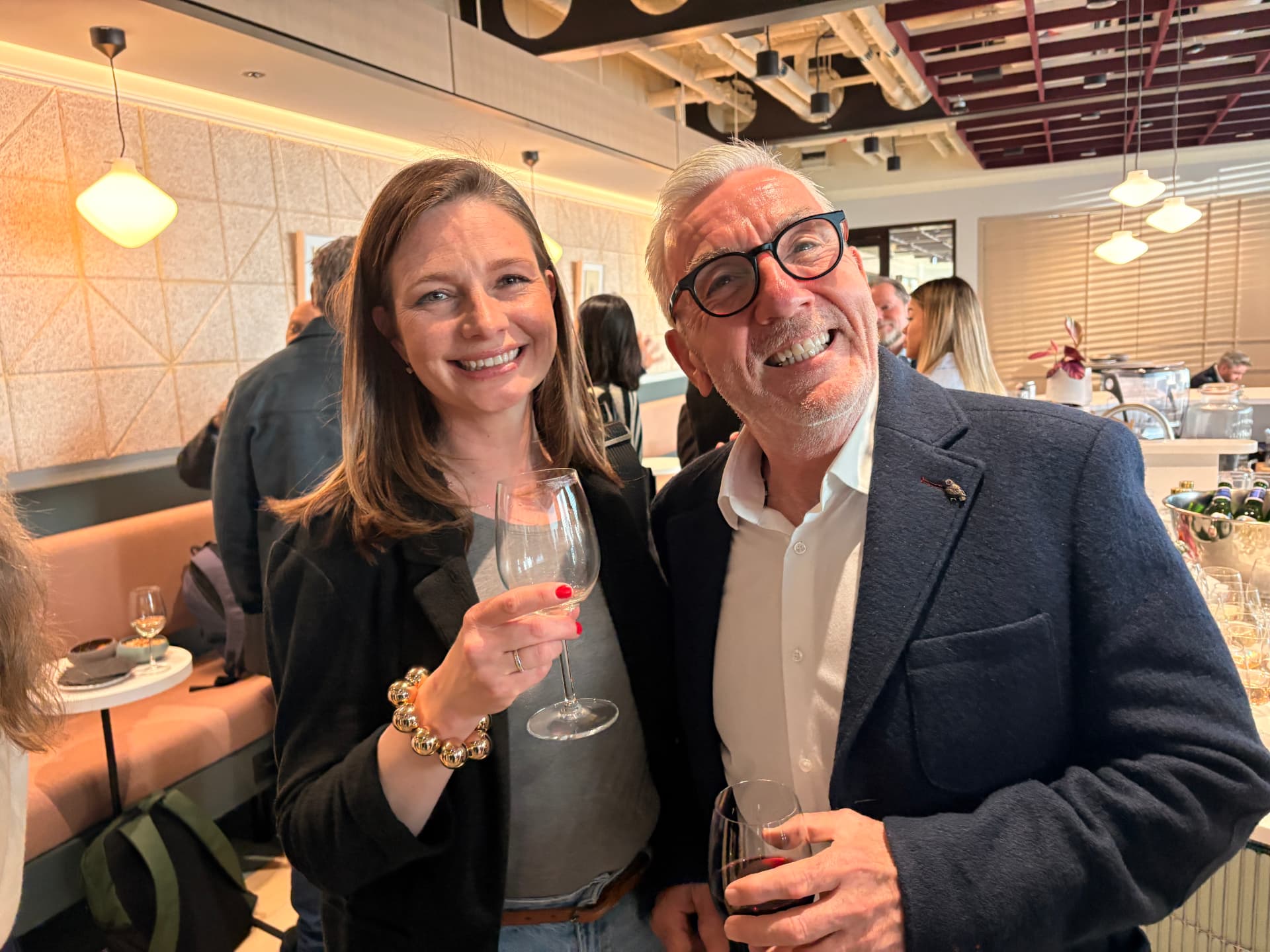 Two networkd members laughing together over a drink at an event