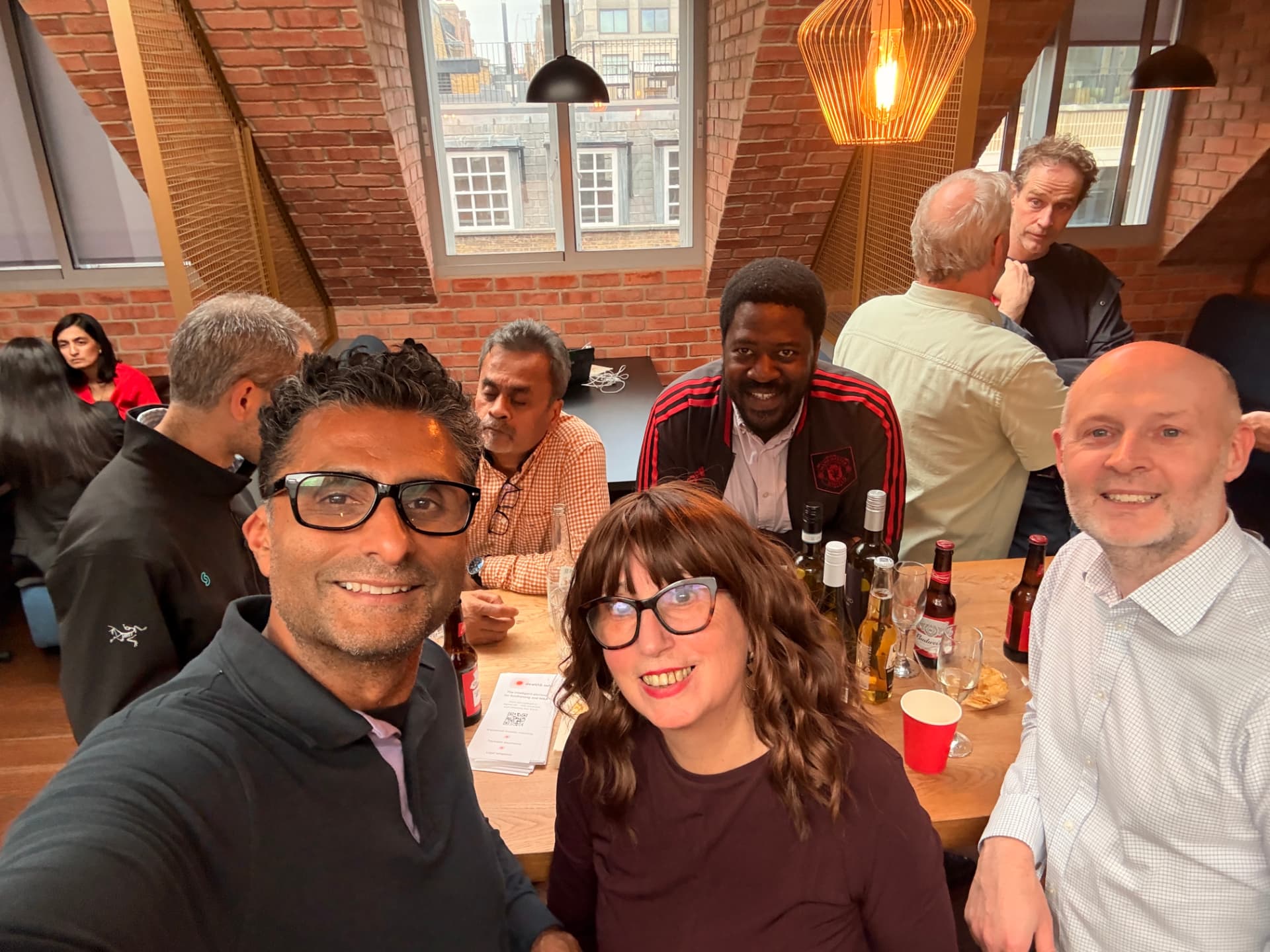 Members gathered around a table talking over drinks