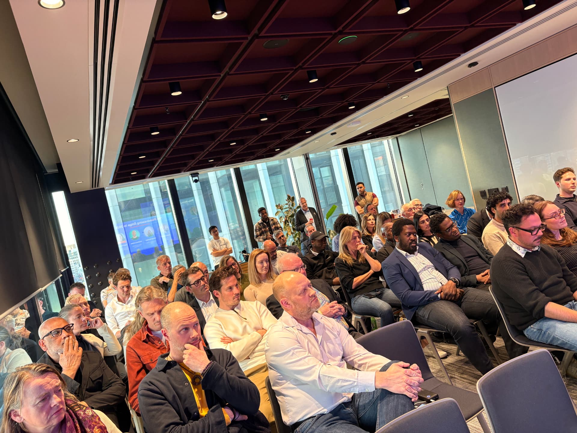 A full room of attendees listening to a talk at a networkd event